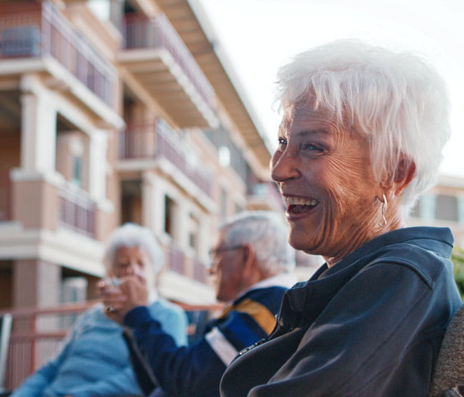 A woman smiles at someone off-camera.