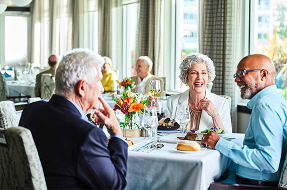 A group of seniors smiling dining together.