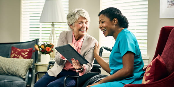 Nurse talking to women in wheelchair.